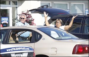 Donna Logan throws her arms in disgust when Toledo Police turn her away from the IHOP Restaurant on Talmadge as federal agents conduct an investigation.