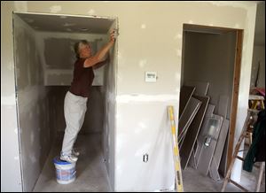 Sister Jane Frances Omlor sands walls inside ‘Little Portion Green,’ the eco-friendly two-bedroom, 1½-bath home.