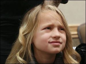 <b>Anna Guzzo</b>, 6, is less than thrilled with the process of having her hair - WEBpbg-tea29-6