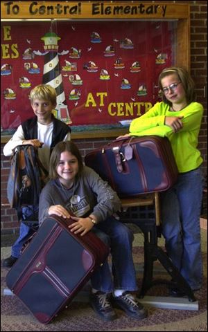 Mark Vajen, Ashley Beiswenger, and Natalie Oberhaus, from left, at Central Elementary School prepare the `Luggage of Love' for giveaway.