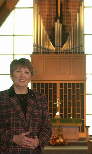 The Rev. Judy Schumaker near the new organ at Faith Community Church.