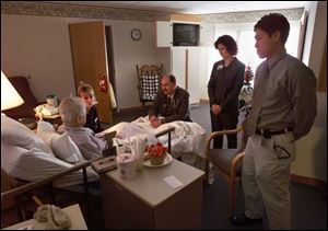 A Hospice of Northwest Ohio patient is visited by registered nurse Diane Smith, at left, Dr. Marc Huntoon, hospice medical director, and Medical College of Ohio students Danielle Barrow and Jason Kim.