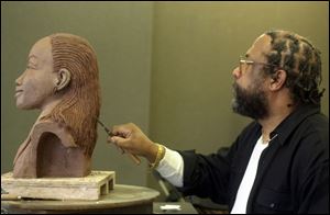 Edward E. Parker, whose work has been exhibited nationally, works on a sculpture of Susan Taylor at the University of Toledo's student union in preparation for her appearance here.