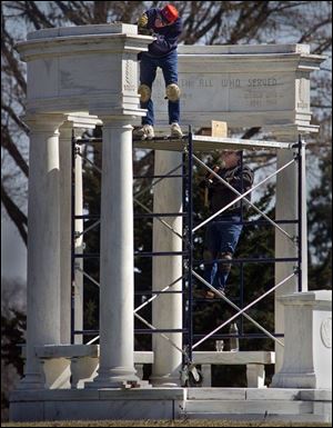 Bill Conrad and Steve Van Grinsven with B.C. Granite of Rockville, Minn., above, work on the memorial at Maple Grove Cemetery, which is being refurbished at a cost of $350,000.