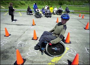 Andy Parsons, a veteran in wheelchair racing, demonstrates the slalom course to his team. He and the Toledo Raptors will compete in Columbus on May 18 and 19.