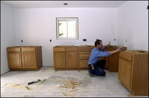 Job supervisor Jeff Mossing levels cabinets at a home in Temperance. Kitchens are among the most popular remodeling projects.