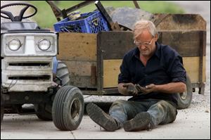 rov tracor01 -  June 4, 2001. Jim Lang takes a look at his dirty hands after fixing his broken trailer. Lang was taking a load of scrap metal to a friends when the trailer he built broke while going over a railroad track on South Main Street in Lima. Blade photo by Allan Detrich