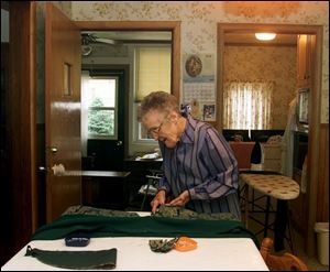 Vi Ardner sews a vestment at her Tiffin home. The General Electric retiree estimates she has stiched about 3,000 of the garments over the years.