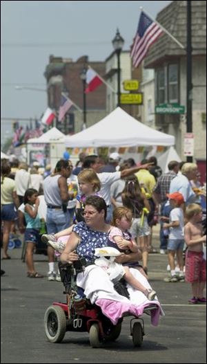 Kalee Callihan, 4, and her sister, Britenee, 3, get a ride down Lagrange Street from their aunt, Zena Cole during the 18th annual Polish Festival.