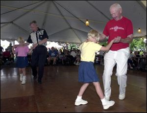 Elizabeth Mende, 7, polkas with Don Wozniak, right, while her twin, Veronica, takes a spin around the floor with Bill Klein.