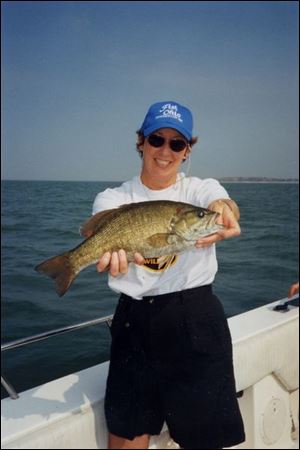 Vicki Mountz, producer of Wild Ohio, a TV program produced by the Ohio Division of Wildlife, hefts a trophy-sized Lake Erie smallmouth bass caught during the making of the program.