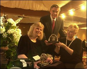 CHAMPIONS: Ann Marie Loutzenhiser, left, and Robert Savage receive awards from Liz Ference, chairwoman of the Dinner of Champions: Triumphs and Treasures. The event benefited the Multiple Sclerosis Society and was held at the Pinnacle.