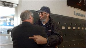 Edward Turner, right, embraces his Toledo attorney, Jack Viren, Jr., before a bus journey back to Chicago.