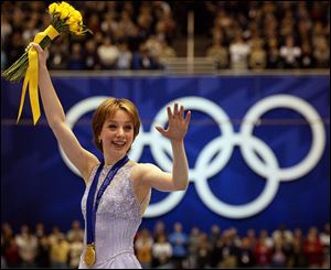 Sarah Hughes of the United States waves with the gold medal at the awards ceremony of the women's skating at the Winter Olympics in Salt Lake City.