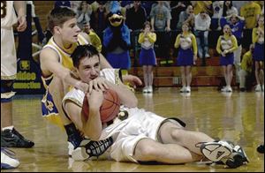 Old Fort's Jason Kline protects the ball from Nate Klaus of Delphos St. John's during last night's Division IV semifinal at Savage Hall. DSJ beat Old Fort 65-61 to advance to Friday's final against Holgate.