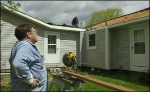 Tim Yerrick watches as volunteers work on the addition being put on his Adrian home.