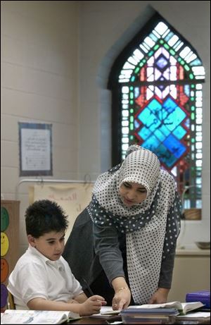 Adam Saie, 9, working on a math problem with teacher Nabeela Hamdan, is at the Islamic School because it provides a connection to his Lebanese heritage.