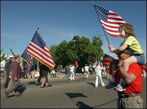 Sierra Cox, 7, perched atop her grandfather, Bob Lopez, has a bird's-eye view of the veterans groups in the Memorial Day parade on Lagrange Street.