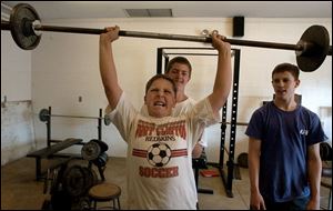 reg rover11p A June, 11, 2002. B.J. Johnson, 13, lifts weights for the upcoming football season as his friends Carey Clum, 13, and junior Adam Urban spot Tuesday at True Lay Stadium in Port Clinton, O. Johnson will play eighth grade football in the fall. Blade photo by Jeremy Wadsworth