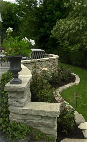 A curved twin-level terrace embraces and protects roses in Bebe and Lee Wesselmann's yard.