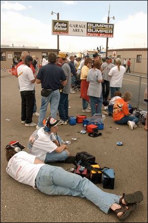 Toledo NASCAR fans Charlie Clingo and his son Tom relax while waiting for drivers to come by for autographs at MIS.