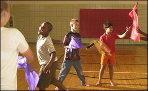 From left, Alyson Sujkowski leads Devante Coleman, Stephen Swafford, and Joseph Sati- nas in a dance program that involves passing cloth flags at Harbor Behavioral Healthcare.