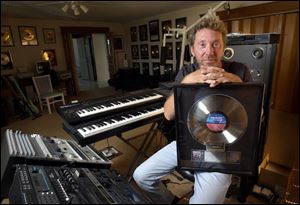 Craig Frost holds the platinum award from 'Like a Rock', earned by Bob Seger and the Silver Bullet Band.