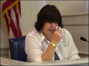 Stabbing victim Laurie Andrich wipes tears as she testifies in the Bowling Green courtroom of Judge Reeve Kelsey.