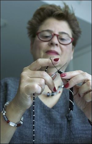 Karen Posner threads a necklace using beads. `It's relaxing. It's therapy,' says the substitute teacher from Sylvania Township, who has crafted custom necklaces and bracelets for friends.