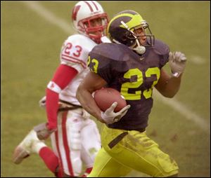 Michigan's Chris Perry, who had a career-high 175 yards rushing, gets past Wisconsin's B.J. Tucker.