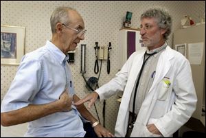 Dr. David Grossman, health commissioner for Lucas County and Toledo, speaks with Jerome Palazzolo in his private practice on Alexis Road.