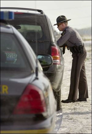 Sgt. Glenn Peterson of the Ohio Highway Patrol talks to the driver of a sport utility vehicle that he pulled over for speeding along State Rt. 163 west of Oak Harbor.