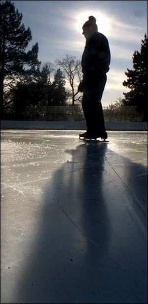 Lone skater Don Metzger casts a dark shadow as he takes his time strolling around the Ottawa Park skating rink during a sunny and mild winter afternoon. He skates at the park about 3 to 4 times a week, while his wife sits inside the rink and reads a book.