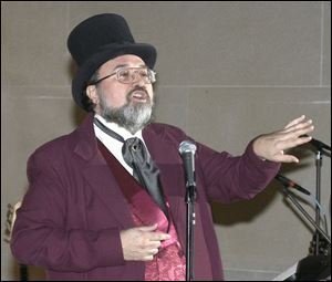 Rick Hagg entertains the crowd at the library with his rendition of a song from the War of Toledo musical.