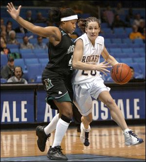 Toledo's Kelly Walker drives against Marshall's Amy Reed. Walker scored 17 points as the Rockets advanced.