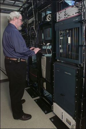 Dan Baker checks Internet servers at TotalLink facility.