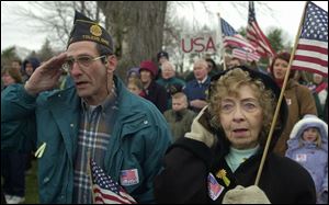 Ray Simoni, a Vietnam veteran, and his friend, Helen Osborne, show support for the U.S. troops fighting in Iraq. The pair were part of a rally yesterday at Woodland Park in Perrysburg. About 300 people, many with children serving in the armed forces, attended the rally.