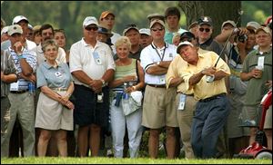 Even in practice, Arnie has his army. At Inverness yesterday, past champion Arnold Palmer hits out of the rough on the ninth hole before a horde of attentive fans.