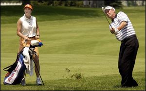 Buddy Alexander, one of 29 amateurs in the field, plays a practice round at Inverness. His wife, Joan, is his caddie.