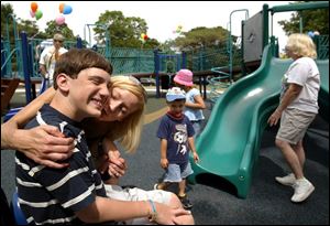 Marcus Meyers, 14, of Holland, enjoys the dedication of the disabled-accessible playground at Walbridge Park with his stepmother, Nikki. 