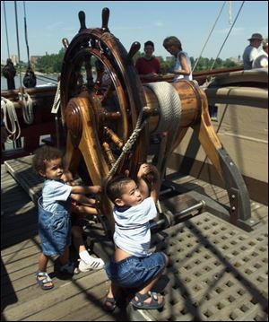 Eshon Howard, 4, behind his brother Julian Howard, 1, and Jaden Fordham, 4, right, take the wheel of the Bounty.