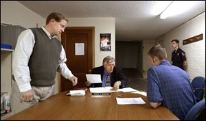 Bowling Green city prosectuor Matt Reger, left, assists Magistrate Tom McDermott in figuring out a plea for a defendant appearing in West Millgrove's mayor's court.