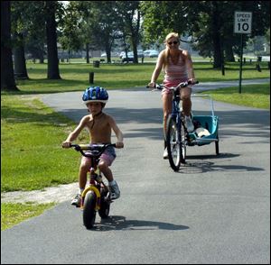 Nbr Photo by Don Simmons Aug 21, 2003  Carson Montz age 5 along with his mom Jenny Montz and his brother ( behind mom in cart) Spencer Montz age 2 enjoy biking in Olander Park