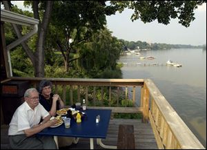 SERENE: Toledo couple Ted and Lynn Ross enjoy the wide river view from the patio at the Lighthouse Cafe. They like to eat there once a week.