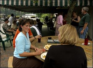 SCHMOOZING: Kristen Baker, left, of Houston, and Lou Anna Ervin, of Millbury, visit over drinks and appetizers on the patio at Loma Linda's on a recent weekend night.