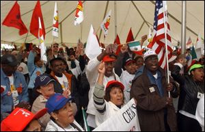 Marchers rally inside a tent at Golden Rule Park.