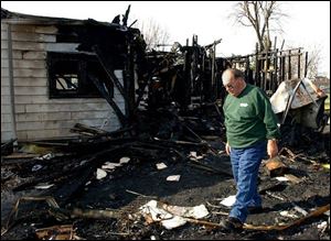 Richard Rickard picks through the rubble of his home in Leipsic in search of personal effects that survived the fire.