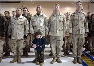 Little Joshua Vasick joins his grandfather, Rudy Santibanez, in formation at the National Guard base. At left is Jose Barra; to the right are Matthew Boose and Dan Bittaker.