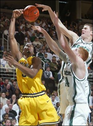 MSU s Paul Davis blocks a shot by UM s Chris Hunter. Davis scored 22 points.