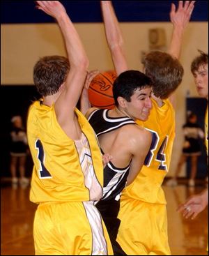 Otsego's Damien Montelongo, center, tries to squeeze through Woodmore's David Bowen, left, and Nick Arndt.